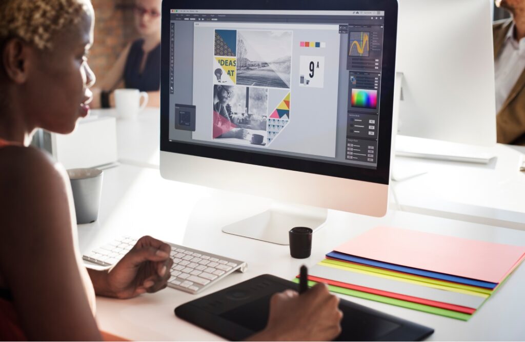 Designer trabalhando com mesa digitalizadora diante de monitor, ilustrando a computação gráfica