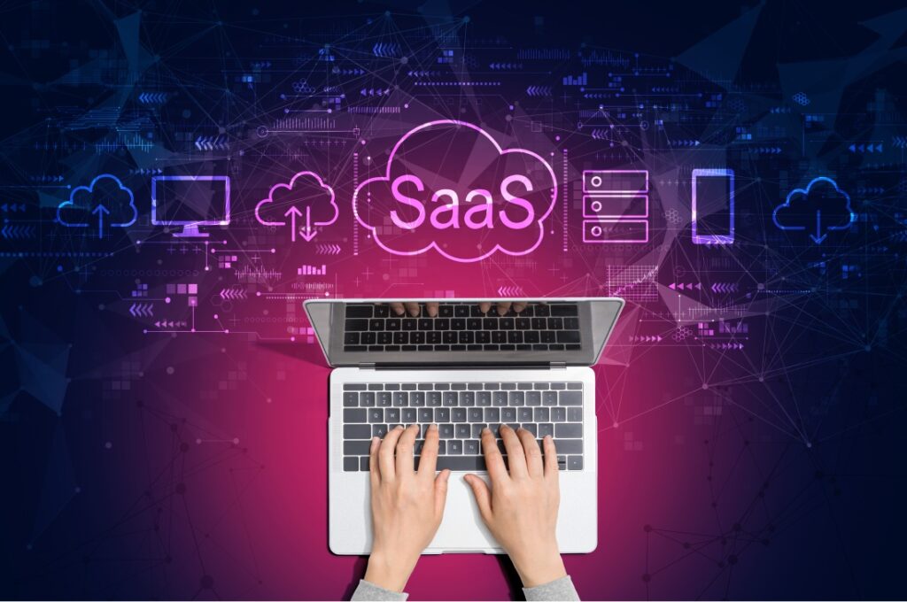 Mãos digitando em notebook com ícones de SaaS e serviços em nuvem